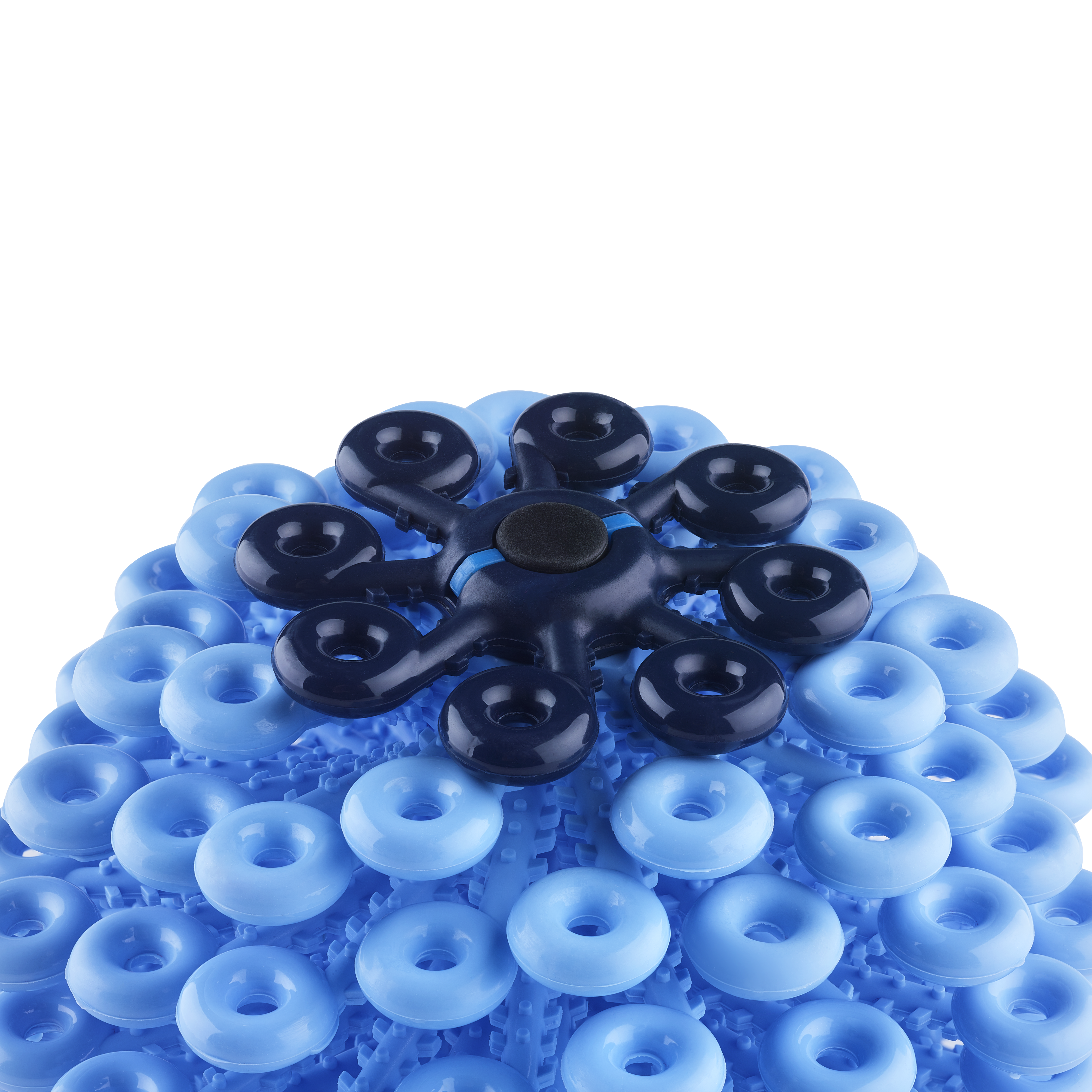 A blue, dome-shaped object featuring rows of circular suction cups and a central dark blue, star-like element with multiple prongs, set against a black background.