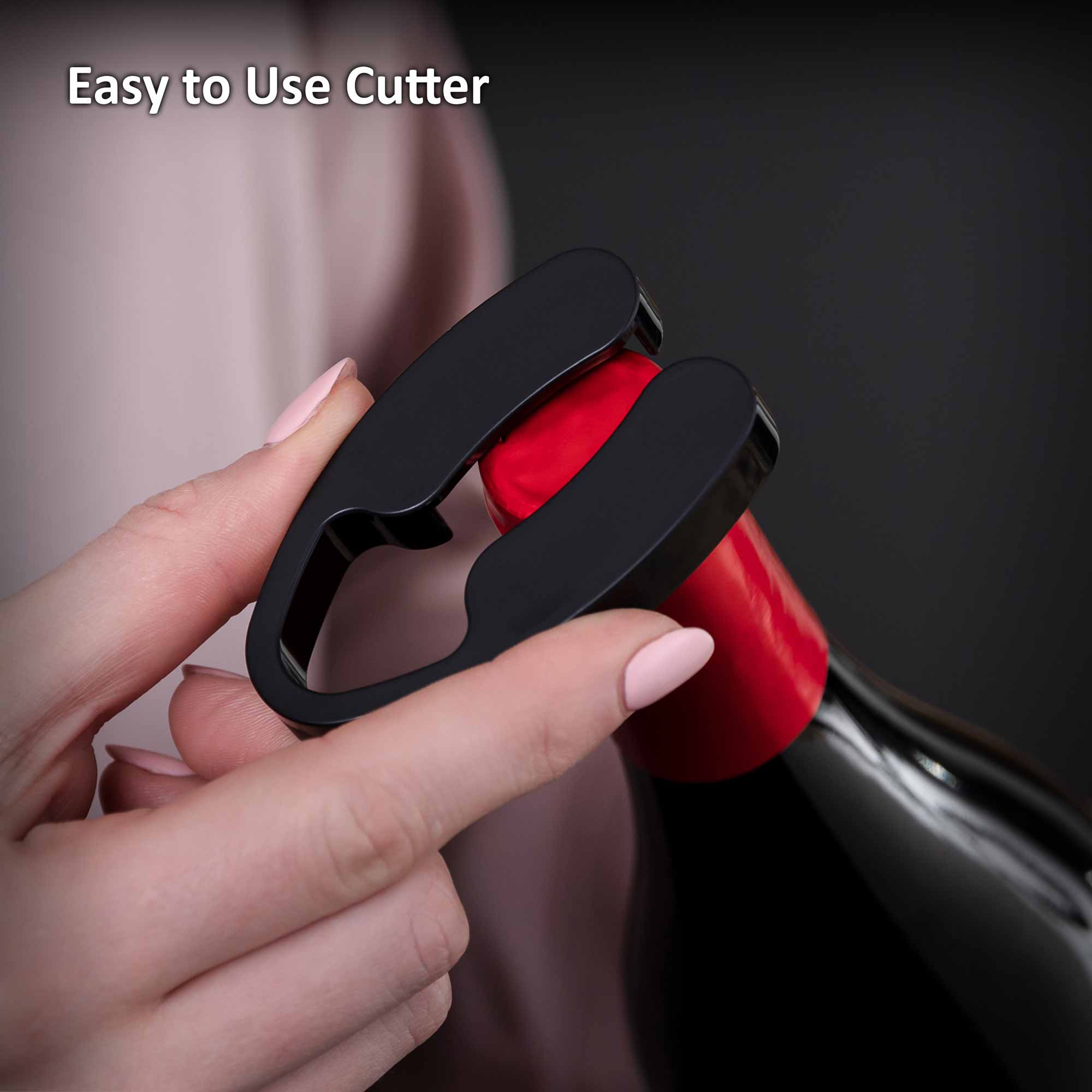 A hand uses a black foil cutter on a wine bottle neck with red foil. Text reads "Easy to Use Cutter." The background is softly blurred.