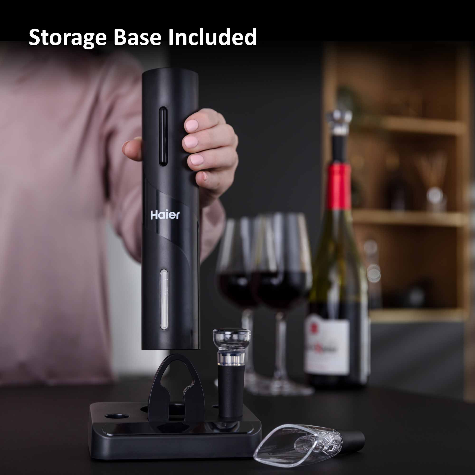 Electric wine bottle opener being held, placed over a sleek storage base, with two glasses of red wine and a wine bottle in the background. Text: "Storage Base Included," "Haier."