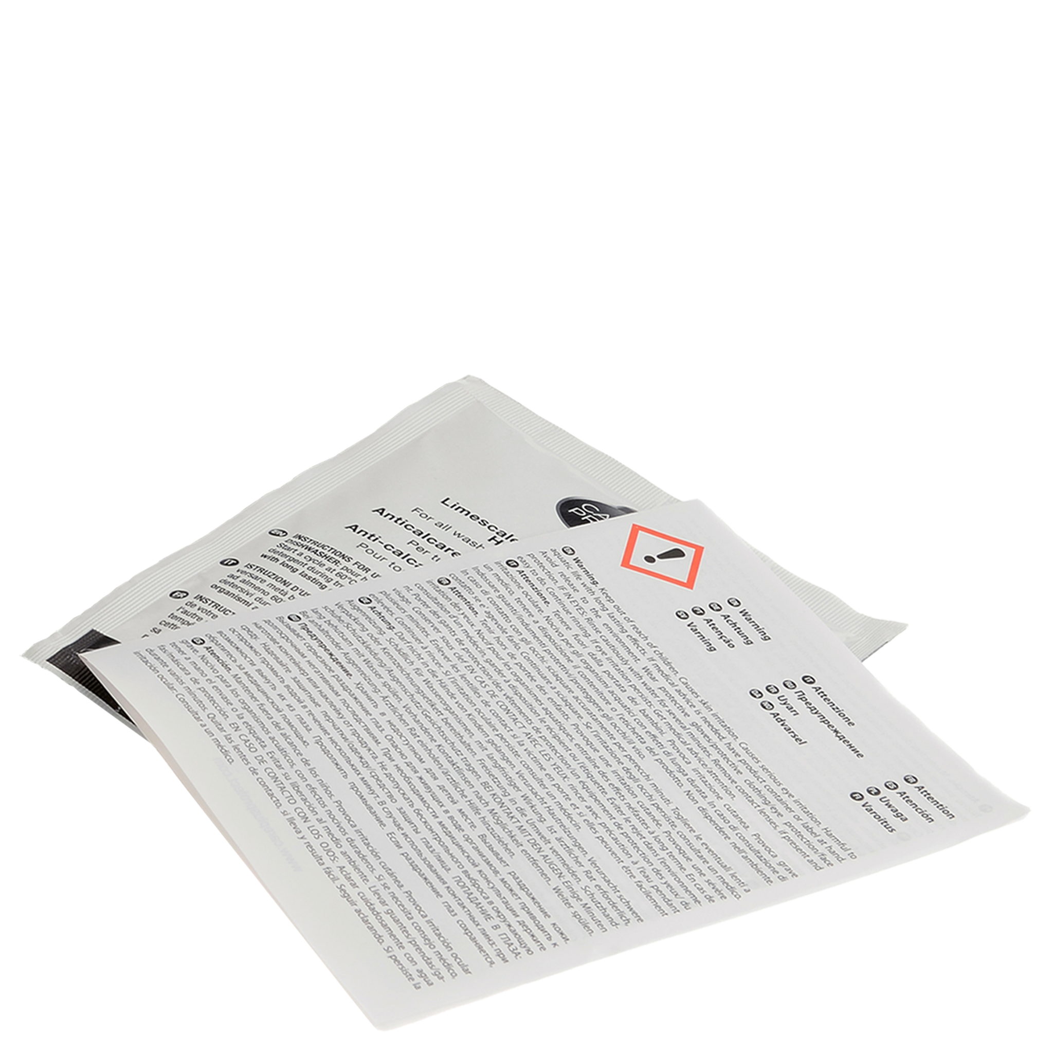 A white packet labeled "Limescale & Detergent Remover" lies on a surface, partially covered by a detailed instruction leaflet featuring a caution symbol. It is used for household cleaning.